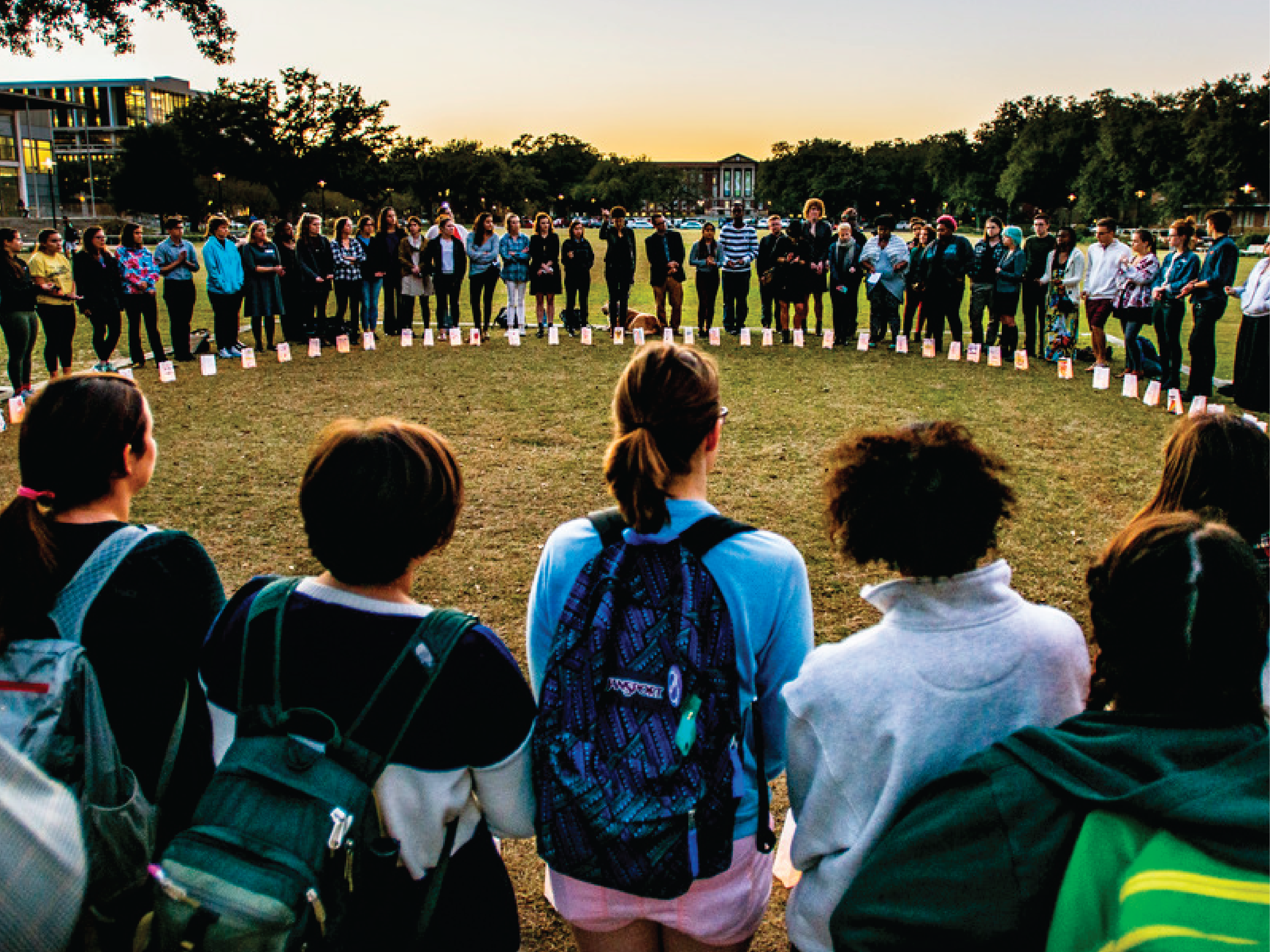 students gather in a circle at sunset to honor those lost to suicide