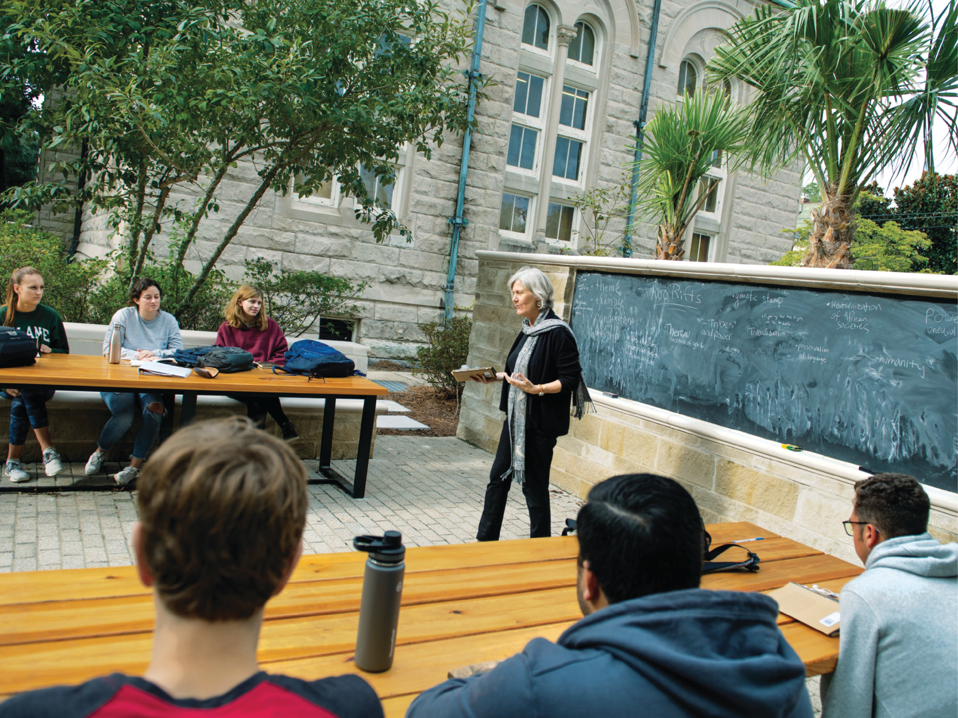 an instructor facilitates a lesson to students using the outdoor classroom