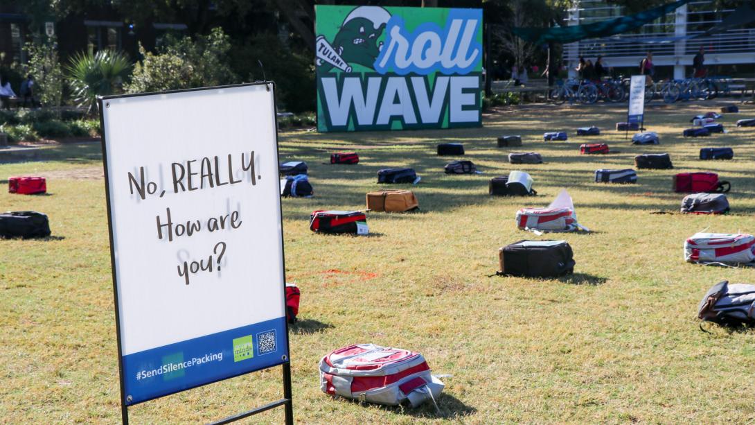 a large sign reads "No really, how are you?" in front of the Send Silence Packing installation on the Berger Family Lawn